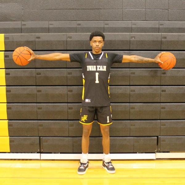 a man holding two basketballs; Men's Basketball